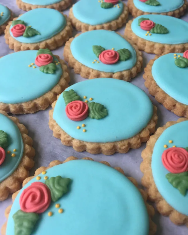 Round blue cookies piped with pink roses