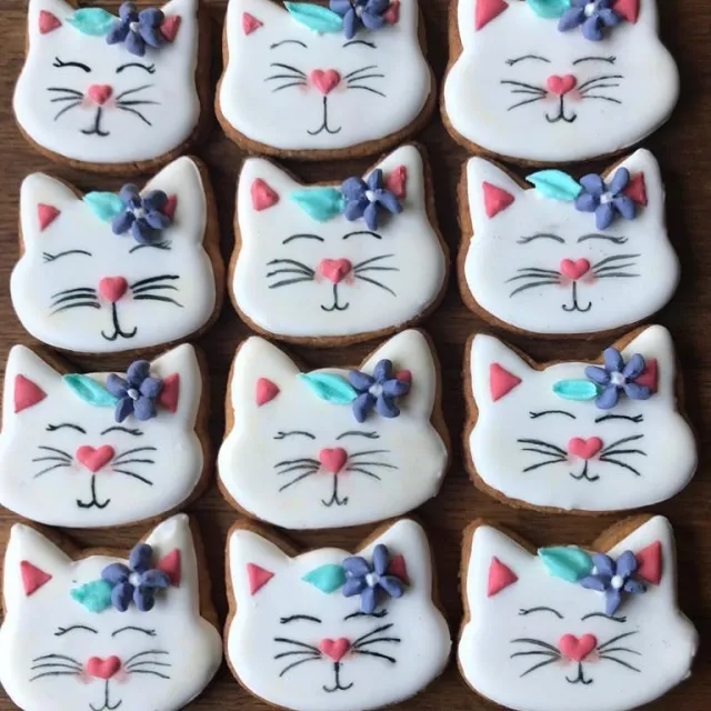 Rows of white cat face cookies with flower crowns