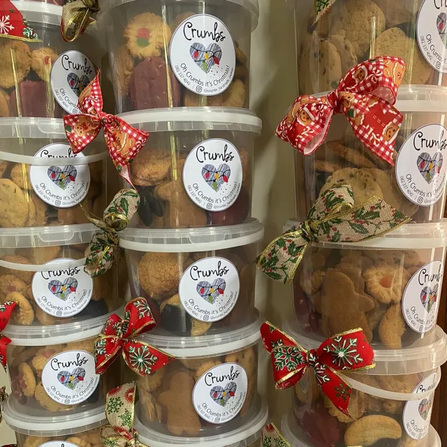 Christmas cookie tubs with red bows and Crumbs labels