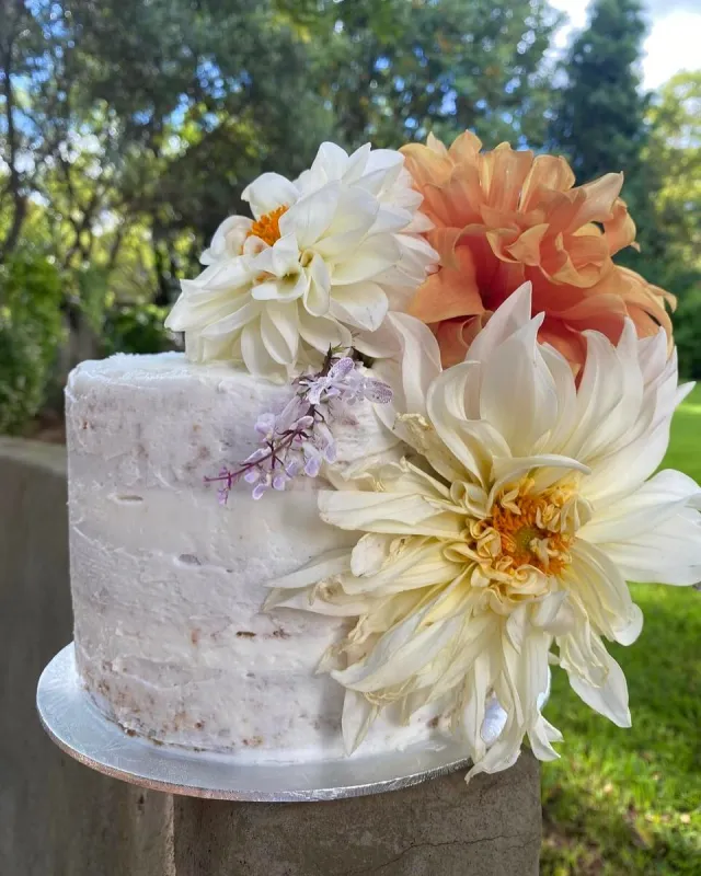 Semi-naked white cake with large cream and peach dahlias