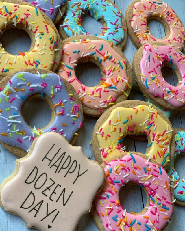 Doughnut cookies with sprinkles and a Happy Dozen Day plaque