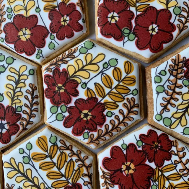 Hexagon cookies hand-painted with red and gold flowers