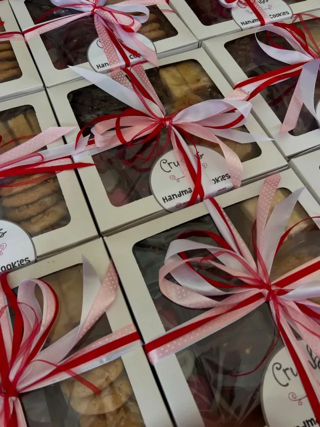 Stack of Crumbs cookie boxes tied with red and white ribbon
