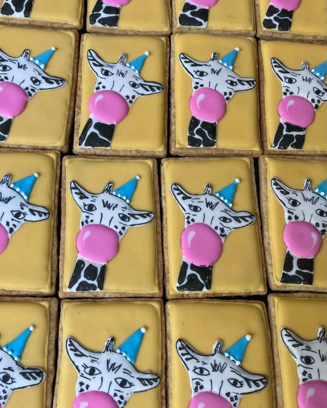 Giraffe cookies in party hats blowing bubblegum bubbles