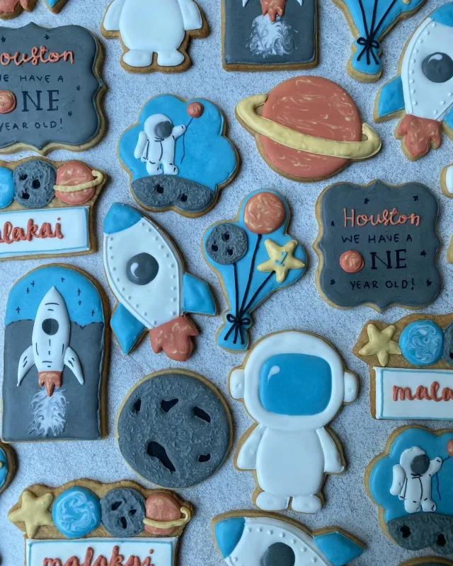 Space themed first birthday cookies with astronauts and rockets