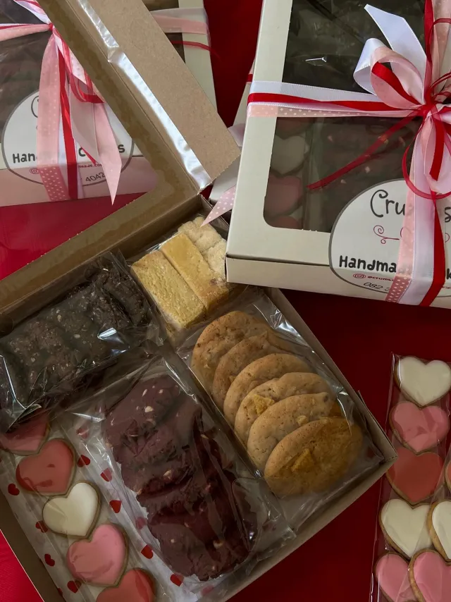 Valentine's boxes of cookies, brownies and heart cookies tied with red ribbon